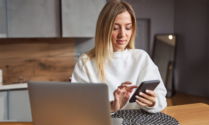 Young, caucasian woman looking at photos on her phone.